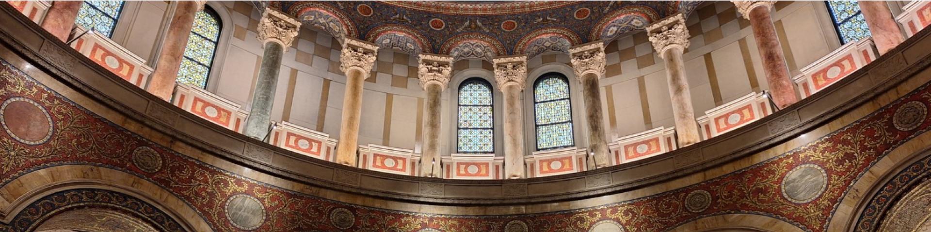 Marble pillars of different colors in a curved section of a cathedral basilica.