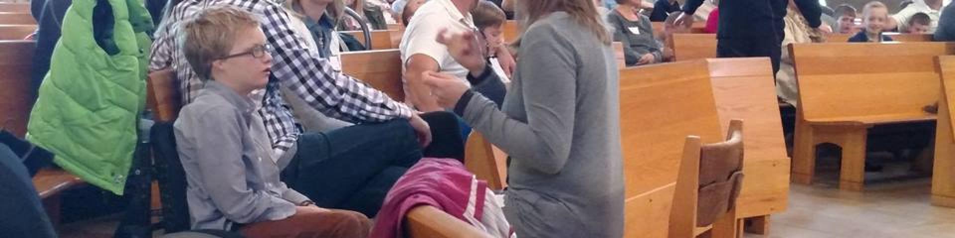 A sign language interpreter and a child in a wheel chair at Mass 