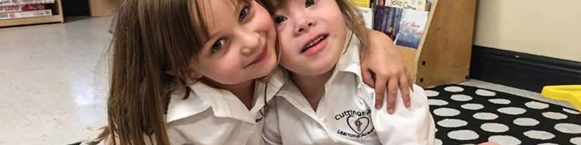 Two young girls in Catholic school, one with a disability