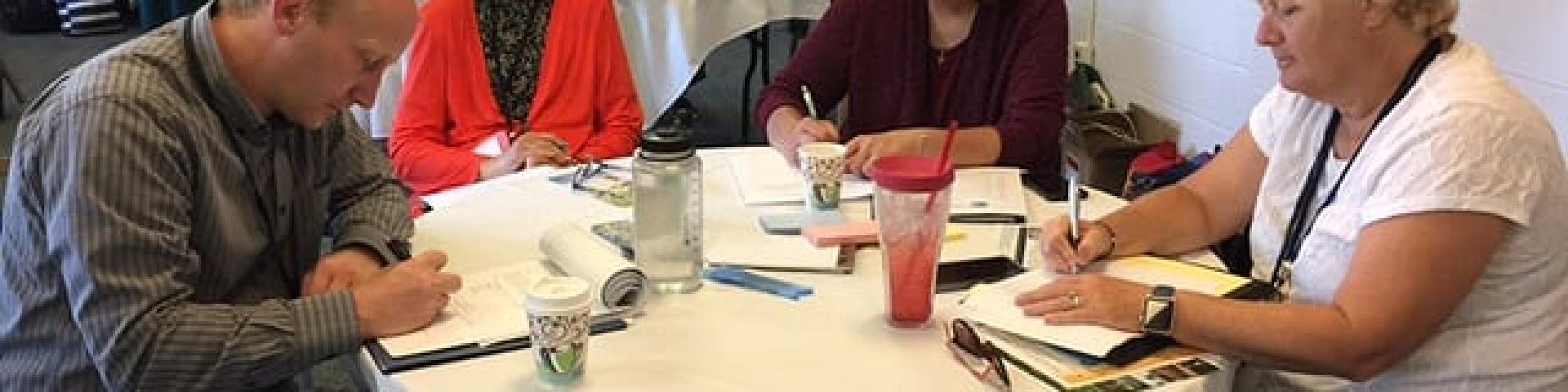 Four people working at a table during a conference