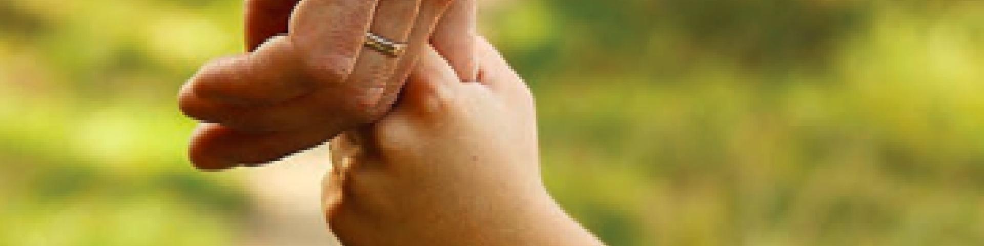 Parent holding the hand of their child