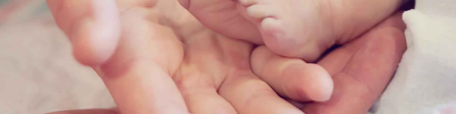 baby's feet and mother's hand