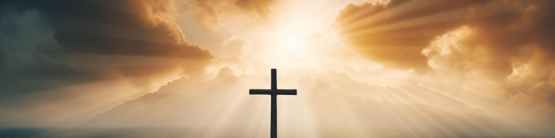 Cross on a hill with sun rays breaking through clouds behind