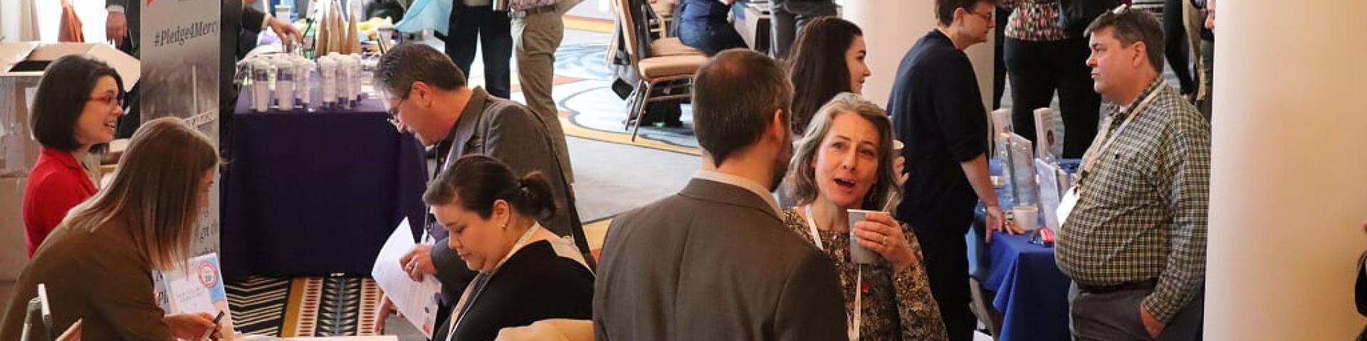 Picture of people networking in an exhibit hall at the Catholic Social Ministry Gathering 