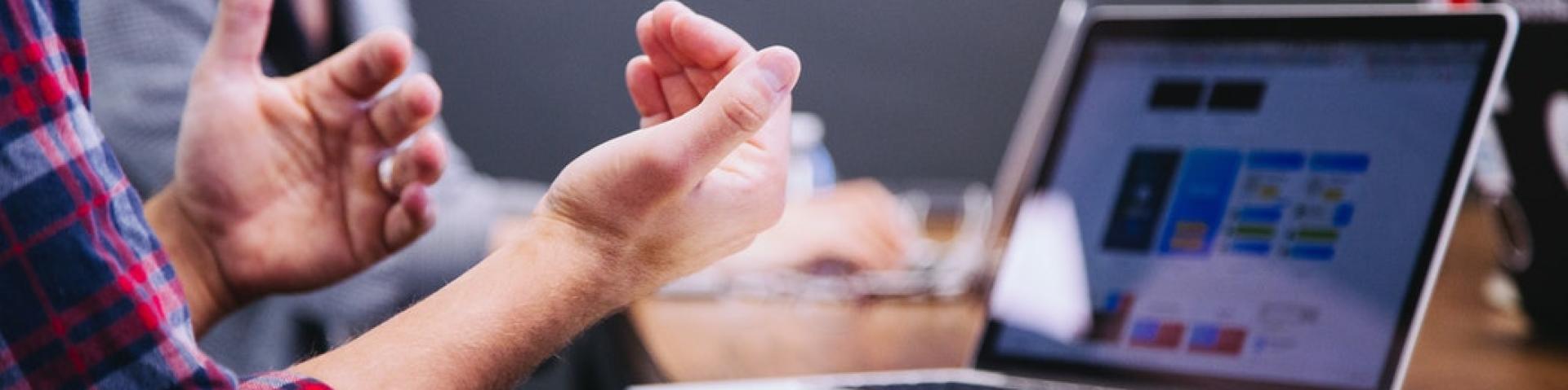 Person with computer talking at a meeting 