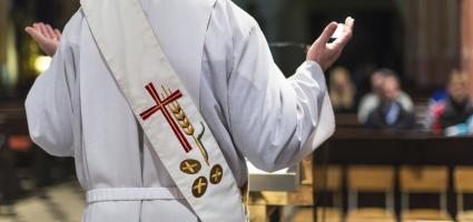 The back of a priest as he celebrates Mass