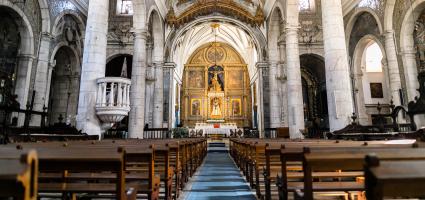 View of an altar and pews from the back of a parish.