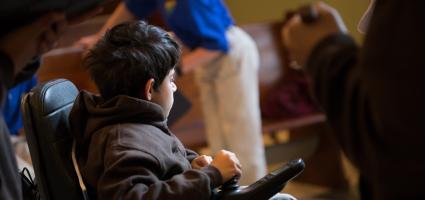 Young boy using an electric chair at mass