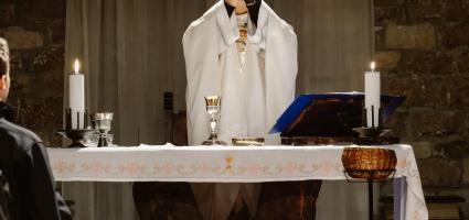 Priest holding up the Eucharist during consecration