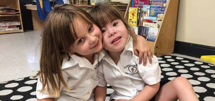 Two young girls in Catholic school, one with a disability 