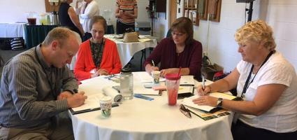 Four people working at a table during a conference