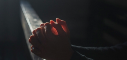 A person's hands folded in prayer 