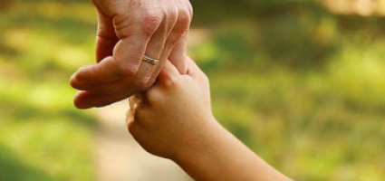 Parent holding the hand of their child 
