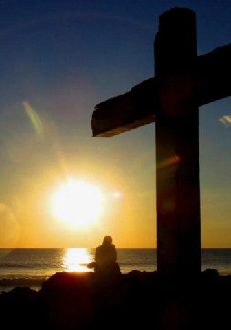 Cross and person praying