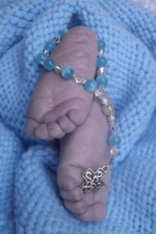 Baby's feet with rosary