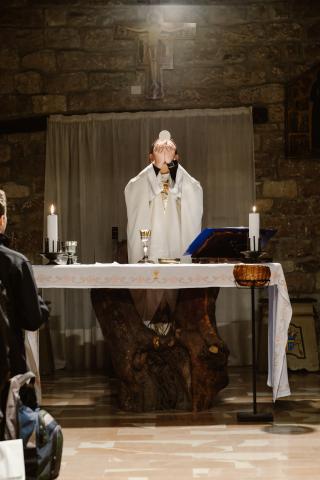 Priest holding up the Eucharist during consecration