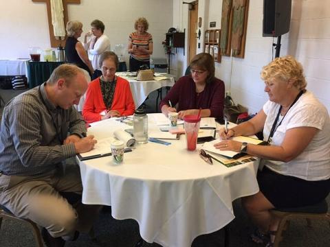 Four people working at a table during a conference