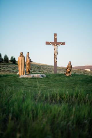 Crucifix in a field with statue of Mary and Saint John