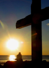 Cross and person praying
