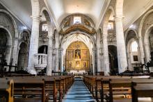 View of an altar and pews from the back of a parish.