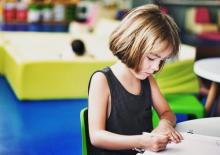 Young girl working on a project at her desk at school 