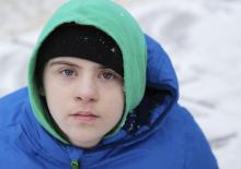 A boy in a winter setting looking at the camera
