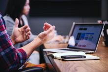 Person with computer talking at a meeting 