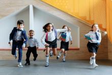 Niños en uniforme corriendo hacía la cámara