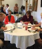 People at a table taking notes during a parish meeting